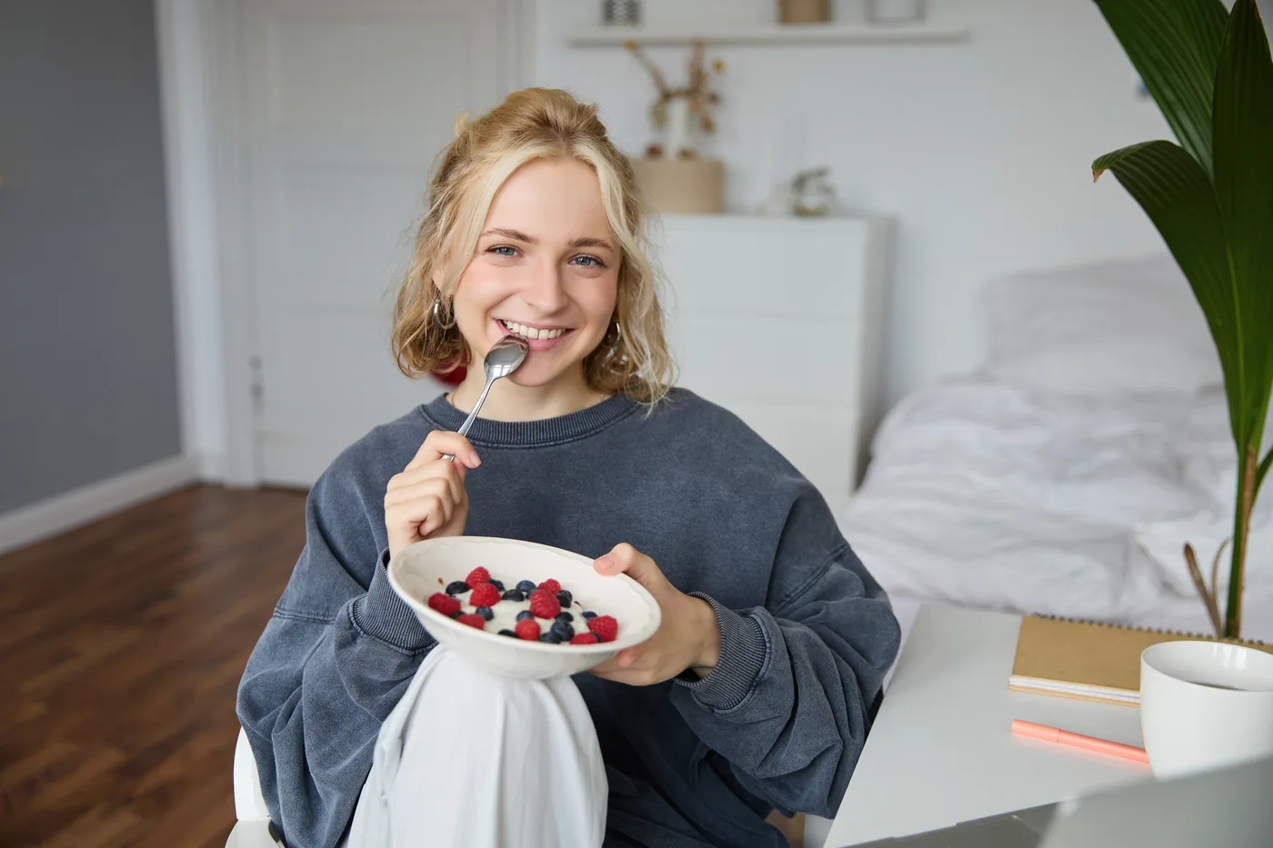Mujer desayunando yogur en casa