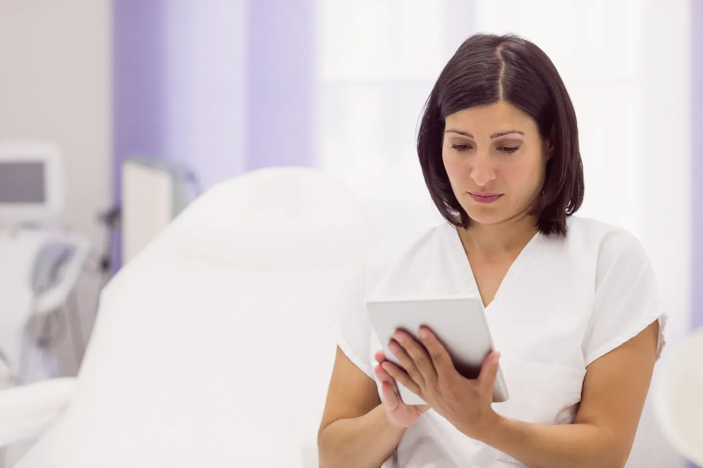 Profesional de dermatología utilizando una tableta en consulta