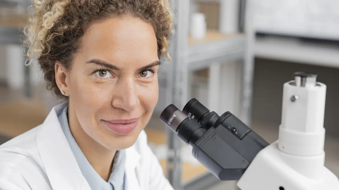 Investigadora analizando muestras con microscopio